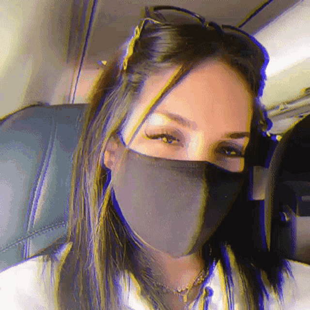 a woman wearing a black face mask and sunglasses