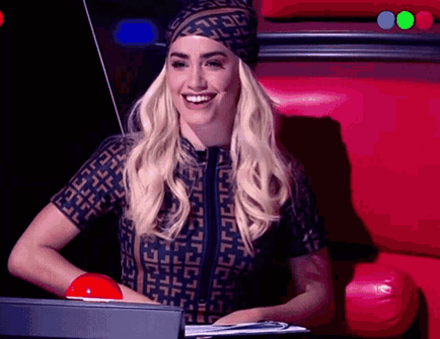 a woman wearing a head scarf is smiling while sitting in a chair