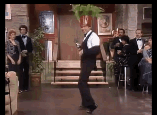 a man in a tuxedo is dancing in front of a group of people in tuxedos