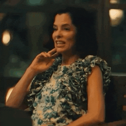 a woman in a floral dress is sitting on a bench .