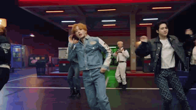 a group of young men are dancing in a parking lot