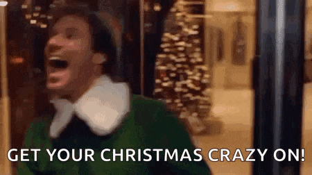 a man in a green elf costume is laughing with his mouth open .