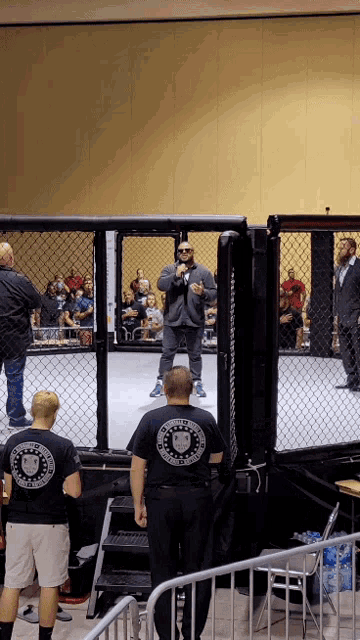 a man stands in a boxing ring wearing a black shirt with a lion logo