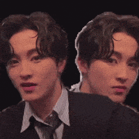 a man in a suit and tie is looking at the camera