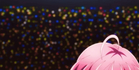 a close up of a person 's head with pink hair in front of a crowd of people .