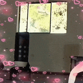 a room with a window and pink hearts floating around it