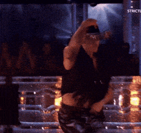 a man in a cowboy hat is dancing in front of a crowd with the words strictly on the bottom