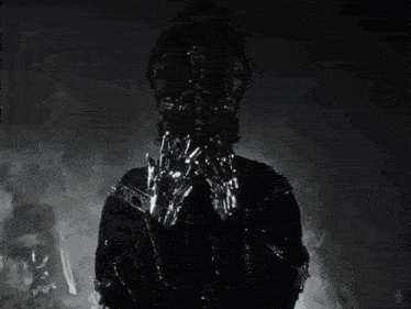a black and white photo of a person with chains around their hands