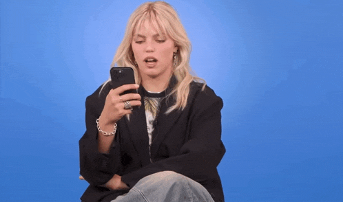 a woman holding a cell phone with the words i 'm renee rapp written above her
