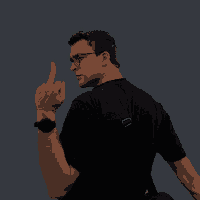 a man wearing glasses and a black shirt is giving a middle finger