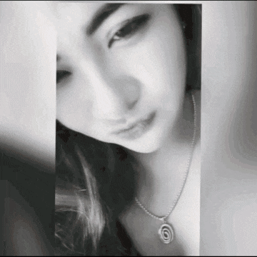 a black and white photo of a woman wearing a necklace and earrings