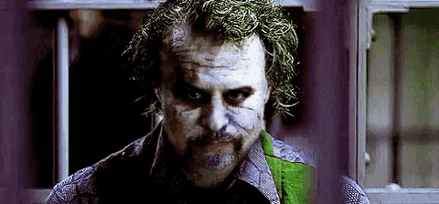 a close up of a man with a beard and a joker mask on his face .