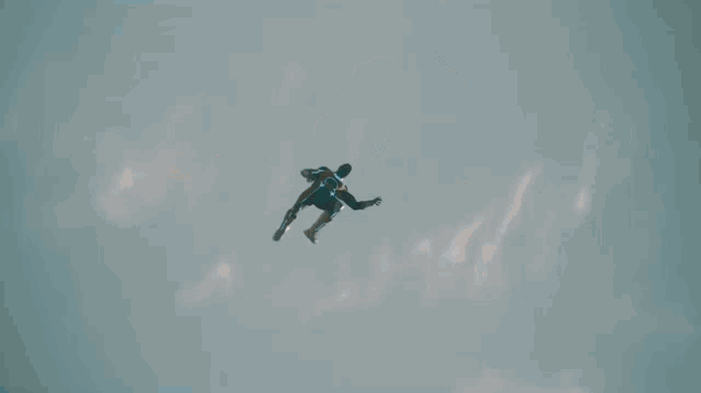a man in a superhero costume is jumping in the air .