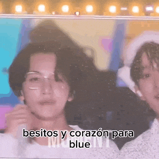 a couple of men standing next to each other with the words besitos y corazon para blue written on the screen .