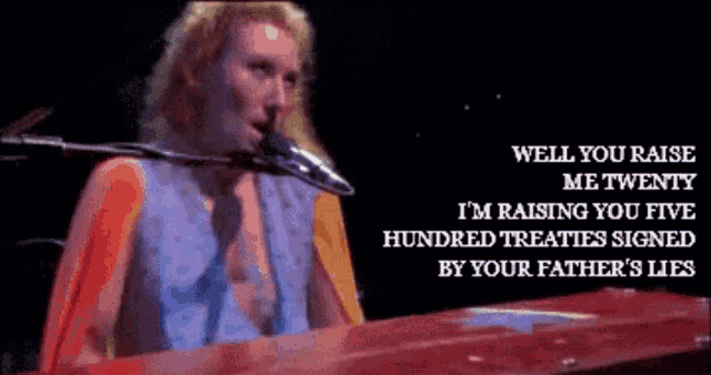 a man is singing into a microphone while playing a keyboard