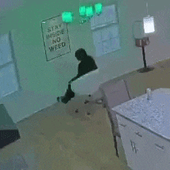 a woman is standing in a room with a sign that says stay inside no weed