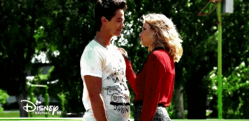 a man and a woman are standing next to each other and kissing .