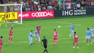 a soccer game is being played in front of an ad for ihg hotels and resorts