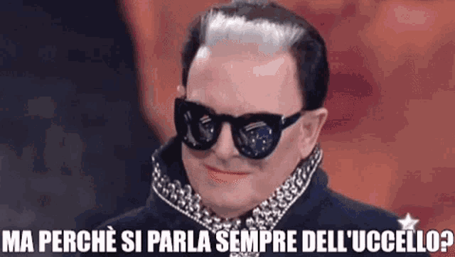 a man wearing sunglasses and a leopard print shirt says ma perche si parla sempre dell ' uccello