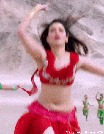 a woman in a red top and a pink skirt is dancing on the beach .