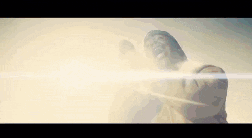 a statue of jesus is standing in front of a bright light .