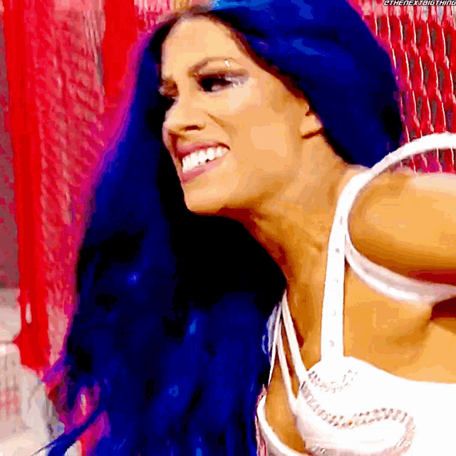 a woman with blue hair is smiling and wearing a white bra
