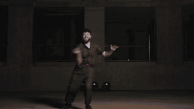 a man in a black shirt is dancing on a stage