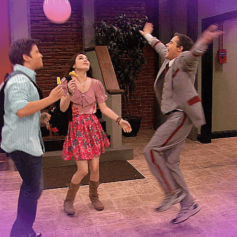 a man in a suit is jumping in the air while a woman in a pink dress holds a banana in her hand