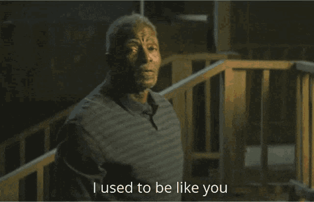 a man in a striped shirt says " until i opened my eyes " in front of a railing