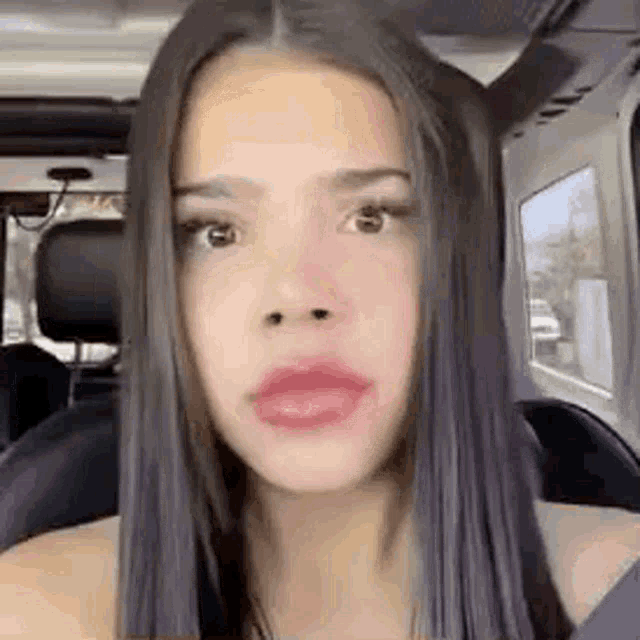 a close up of a woman 's face while sitting in the back seat of a car .