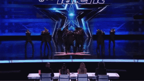 a group of people are dancing on a stage in front of a star with the word talent written on it