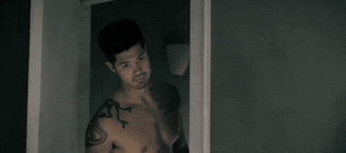a shirtless man with a snake tattoo on his arm