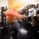 a blurry picture of a woman dancing in front of a crowd of people .