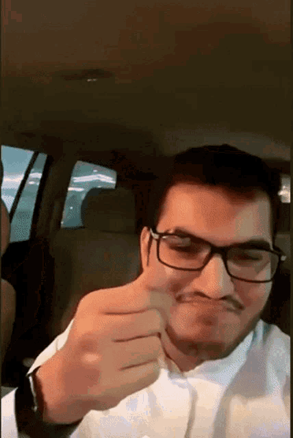 a man with glasses and a mustache is making a face