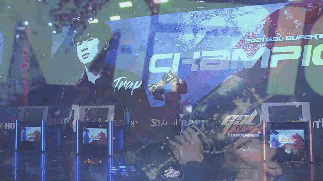 a man holding a trophy in front of a sign that says champ