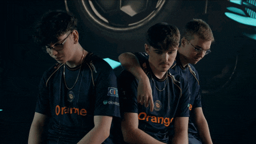 three boys wearing orange shirts pose for a picture