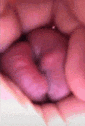a close up of a person 's mouth with a purple object in it .