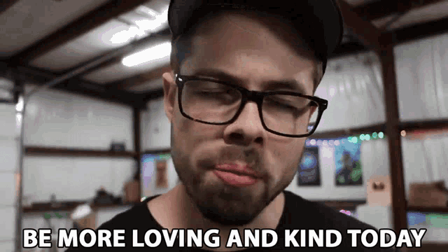 a man with glasses and a beard says be more loving and kind today