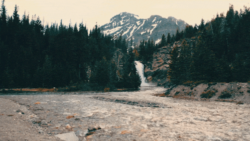a river with a mountain in the background and a waterfall
