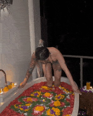 a woman in a bathtub filled with flowers and petals