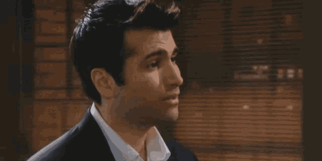 a man in a suit and white shirt looks to the side