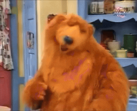 a brown teddy bear is standing in front of a blue shelf