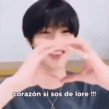 a man is making a heart shape with his hands and the words `` corazon si sos de lore ! ''