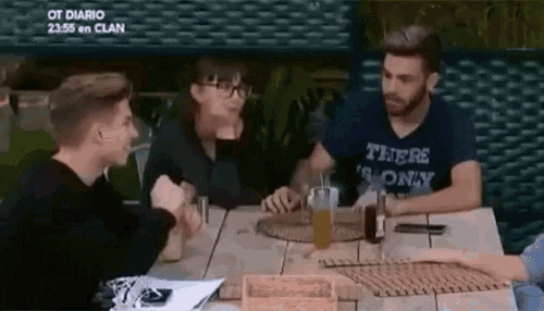 a group of people are sitting at a table with a man wearing a shirt that says there 's only