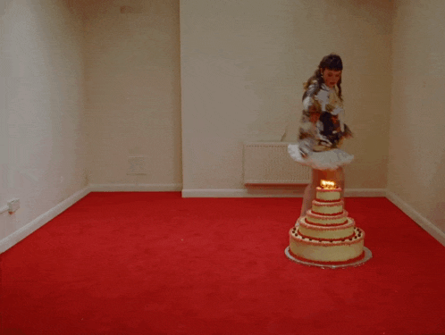 a woman in a tutu stands in front of a cake with candles on it