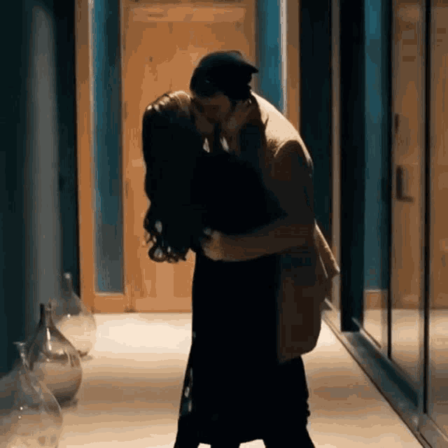 a man and a woman kissing in a hallway