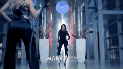 two women are standing in a hallway with the words work b on the bottom right