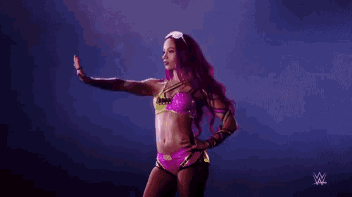 a woman in a pink bikini is standing on a stage .