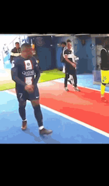 a group of soccer players are standing on a red carpet on a soccer field .