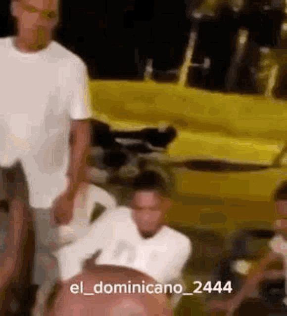 a group of people are standing in front of a yellow car .
